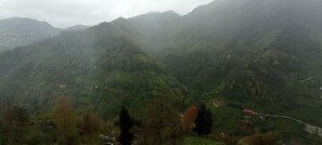 Un paisaje montañoso con una carretera sinuosa y edificios dispersos.