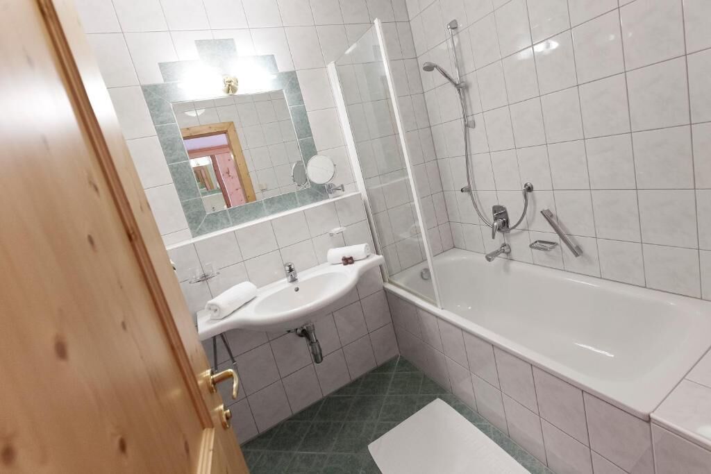 Un bagno con lavandino, specchio, doccia e vasca da bagno.