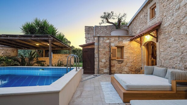 A stone building with a pool and outdoor seating area. - Stone-built cottage with private pool, hot tub and spacious garden! (Rethymno)