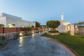 A paved pathway leading to a white building with a stone wall and a tree. - Close to Sandy Beach & Amenities (Rethymno)