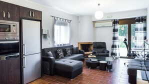 Ein modernes Wohnzimmer mit einem Ecksofa, einem Esstisch und einem Kamin.