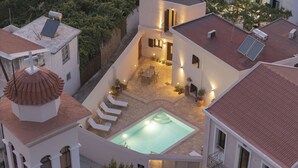 Ein mehrstöckiges Gebäude mit Pool auf dem Dach, einer Außenbereich-Sitzgelegenheit und einer überdachten Terrasse.