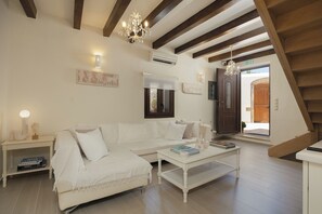 A spacious living room with a white sofa, a coffee table, and a chandelier. - Casa di Vangelis, Summer Village Stay! (Rethymno)