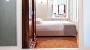 A bedroom with a bed, a window, and a bathroom with a bathtub. - Charming One-Bedroom Residence in Heraklion Center (Heraklion)