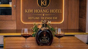 A hotel sign with a bottle of Louis XIII cognac and two glasses. - KIM HOÀNG HOTEL TÂY NINH (Tan Ninh)