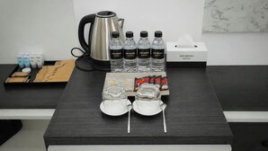 A table with a kettle, bottled water, tea packets, and a tissue box. - KIM HOÀNG HOTEL TÂY NINH (Tan Ninh)