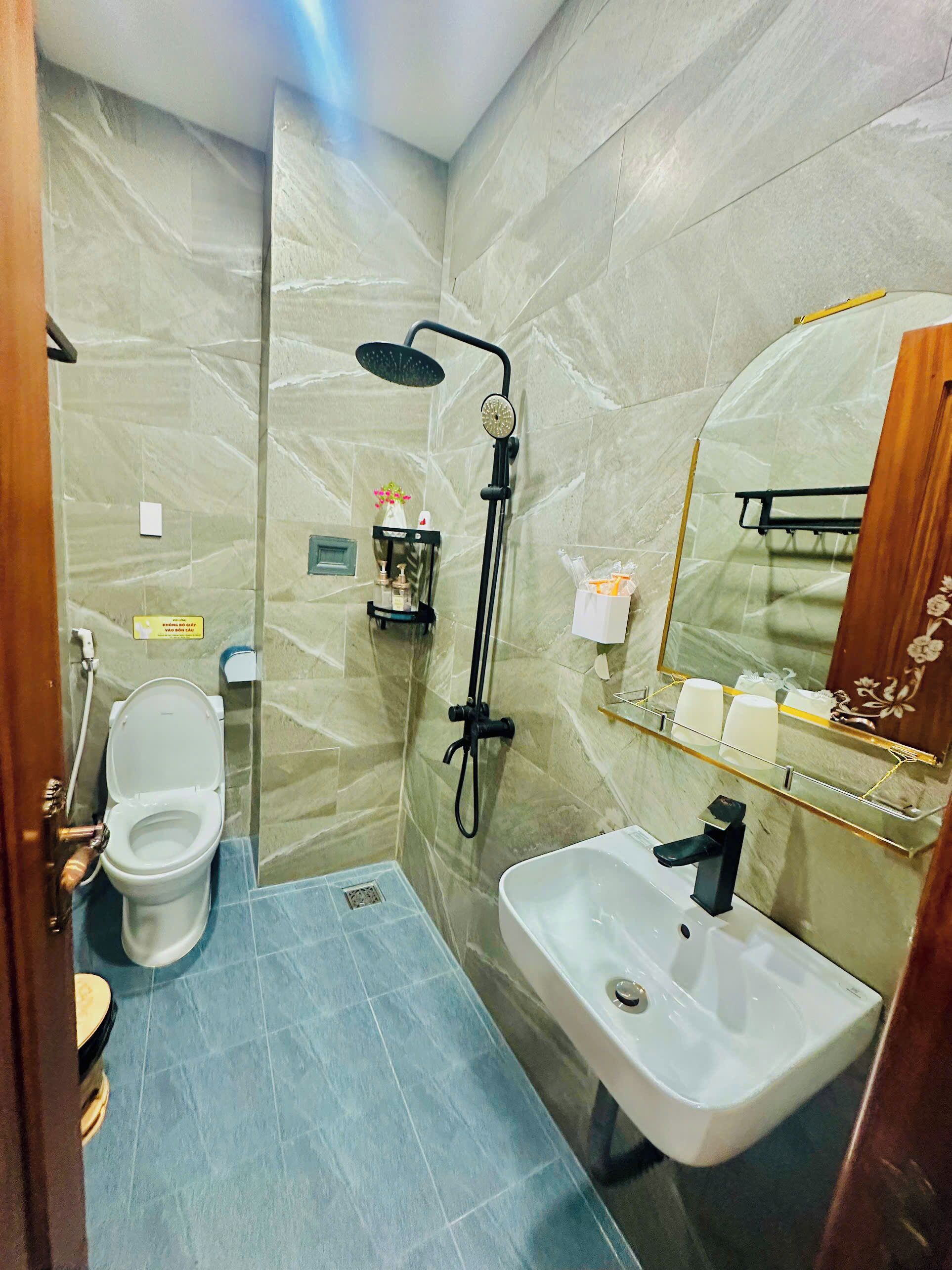 A bathroom with a toilet, shower, and sink.