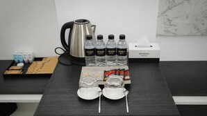 A table with a kettle, bottled water, toiletries, and face masks. - KIM HOÀNG HOTEL TÂY NINH (Tan Ninh)