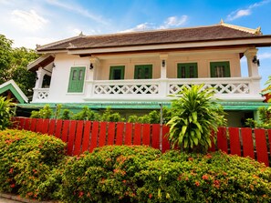 A traditional building with a balcony, green shutters, and a red fence. - Phousi Aphay Hotel (Luang Prabang)