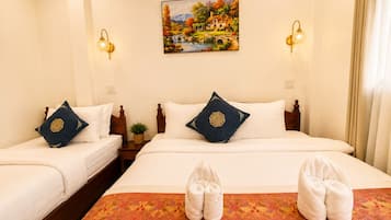 Quarto de hotel com duas camas, um quadro na parede e um par de toalhas sobre a cama.