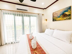 A hotel room with a bed, a painting, and an air conditioning unit. - Phousi Aphay Hotel (Luang Prabang)