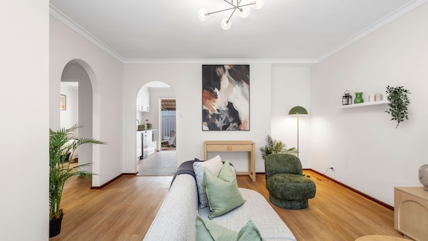 A modern living room with a sofa, a green armchair, a console table, a floor lamp, and a large abstract painting on the wall. - Quiet Comfortable - A Sepal Stay (Perth)