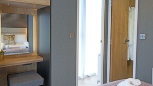 Ein modernes Schlafzimmer mit eingebauter Bank, einem Nachttisch und einem großen Spiegel.