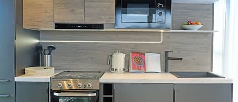 Una cocina moderna con horno empotrado, microondas y electrodomésticos de acero inoxidable.