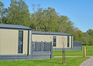 Two mobile homes with metal roofs, wooden walls, and a small tree in front. - 2-bedroom S-Pod sleeps 4 (Landford, Nr Salisbury)