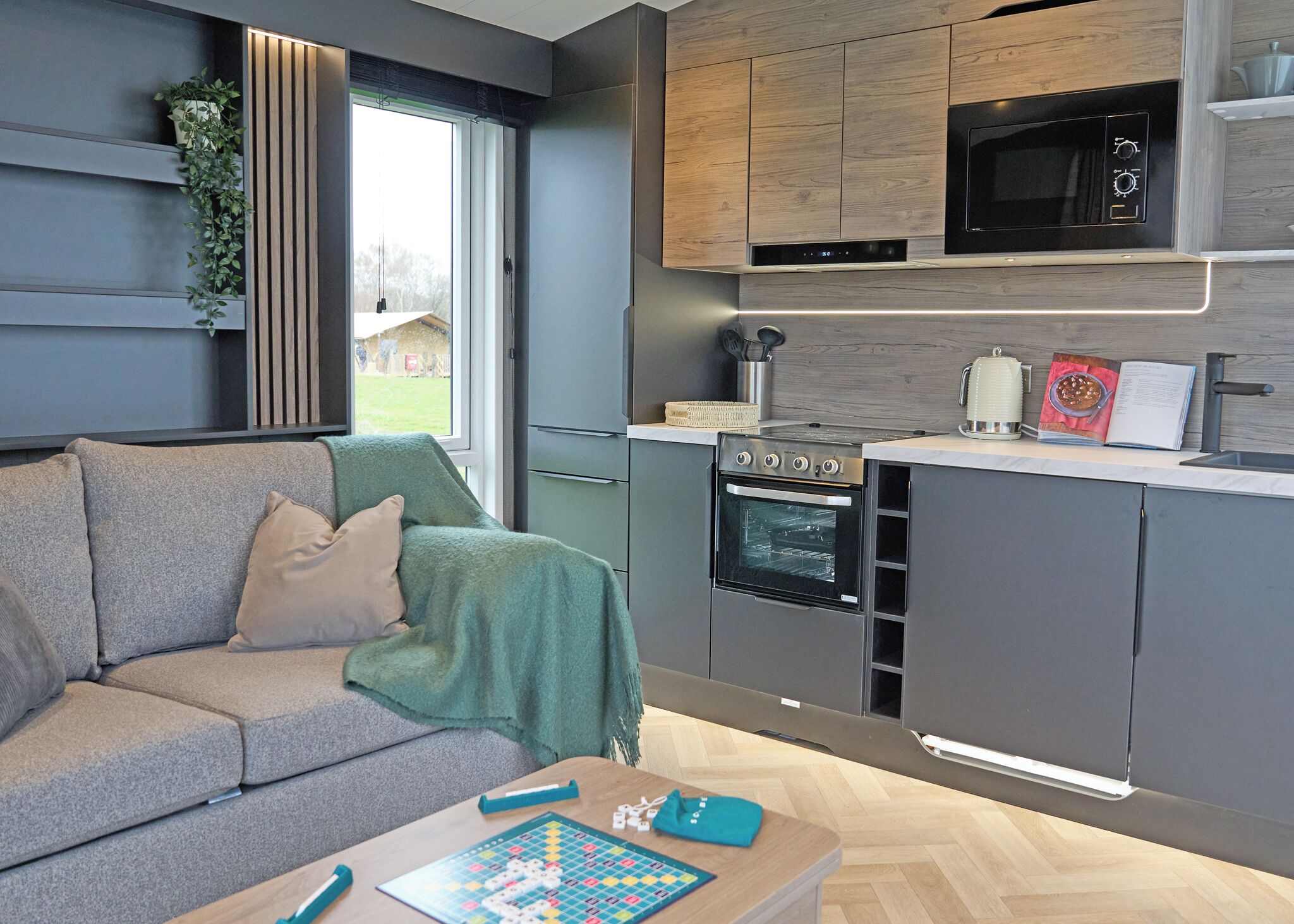 A modern kitchen with a built-in oven, microwave, and a dining area with a table and chairs.