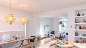 Eine moderne Küche mit Marmorarbeitsplatte, einer Holzbank und zwei Pendelleuchten.