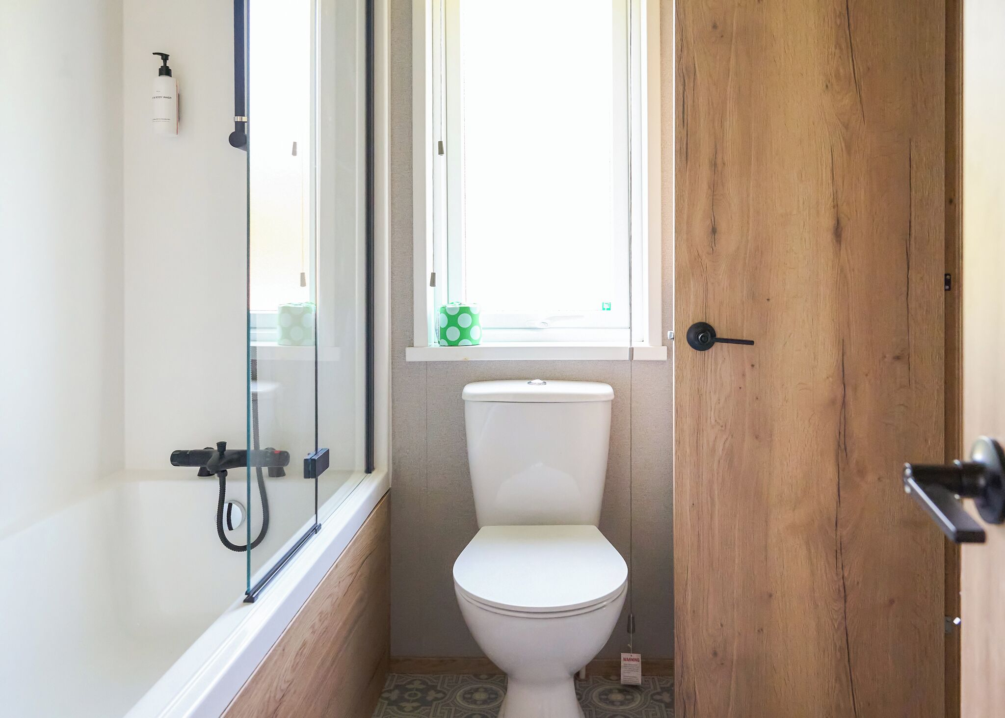 Une salle de bain comprenant des toilettes, un espace douche et une fenêtre avec vue.