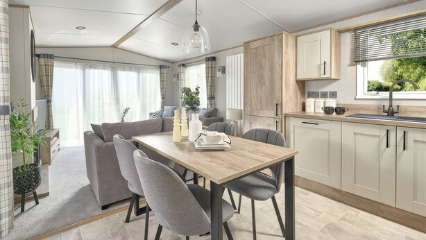 Eine moderne Küche mit Holztisch und -stühlen, einem eingebauten Backofen und einem Fenster mit Jalousien.