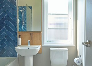 A bathroom with a sink, mirror, and toilet.