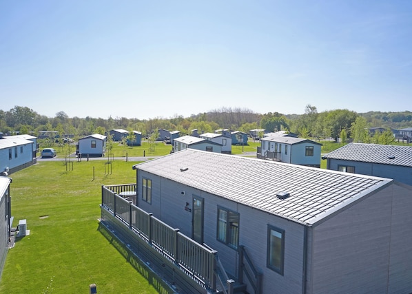 Une rangée de maisons mobiles, avec une pelouse verdoyante et un ciel dégagé.
