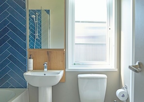 Een badkamer met een wastafel, spiegel en toilet.