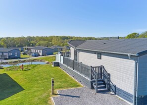 A residential area with houses, a small pond, and a grassy area. - Autograph Glass House Hot Tub 2 Luxury Slps 4 (Landford, Nr Salisbury)