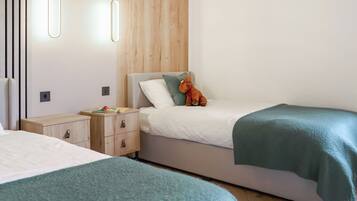 Ein modernes Schlafzimmer mit zwei Betten, einem Holzkopfende, Nachttischen und einer hängenden Leuchte.