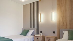 A modern hotel room with two single beds, a nightstand with a lamp, a wooden panel wall, and a ceiling light fixture. - Autograph Kos Hot Tub 2-bedroom Luxury Lodge slp 4 (Landford, Nr Salisbury)