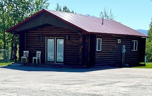 Una baita in legno con tetto in metallo, due ampie porte in vetro e il numero '2950' sulla facciata.