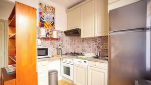 Une cuisine équipée d’un four à micro-ondes, d’une cuisinière, d’un four et d’un réfrigérateur.