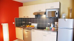 Eine Küche mit Geschirrspüler, Mikrowelle, Kühlschrank und Spüle.