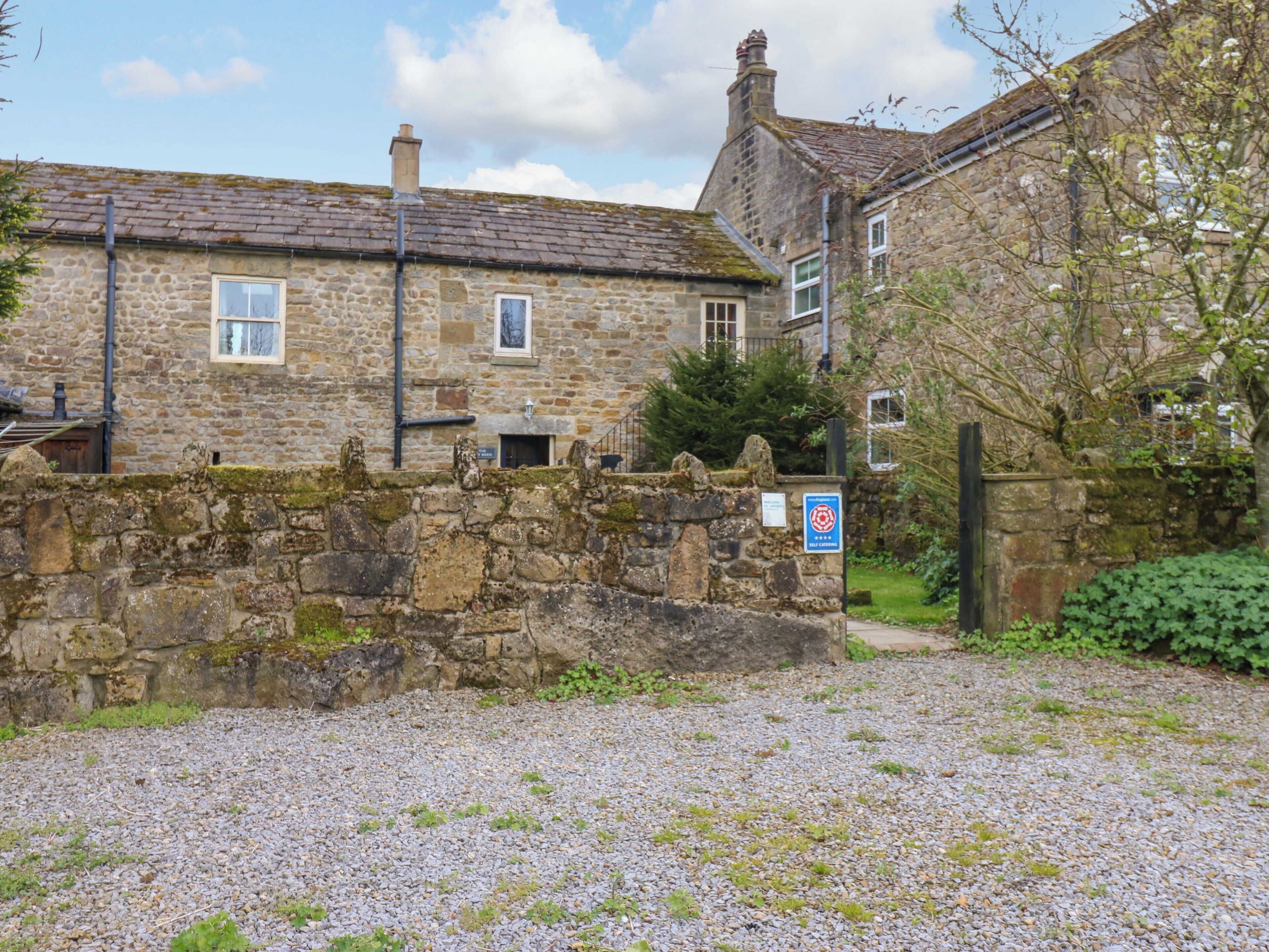 A stone building with a gravel driveway and a sign indicating a private road.