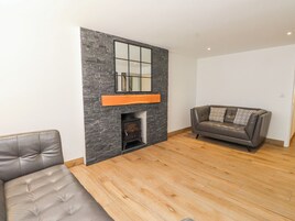 Una sala de estar moderna con chimenea, un sofá y piso de madera.