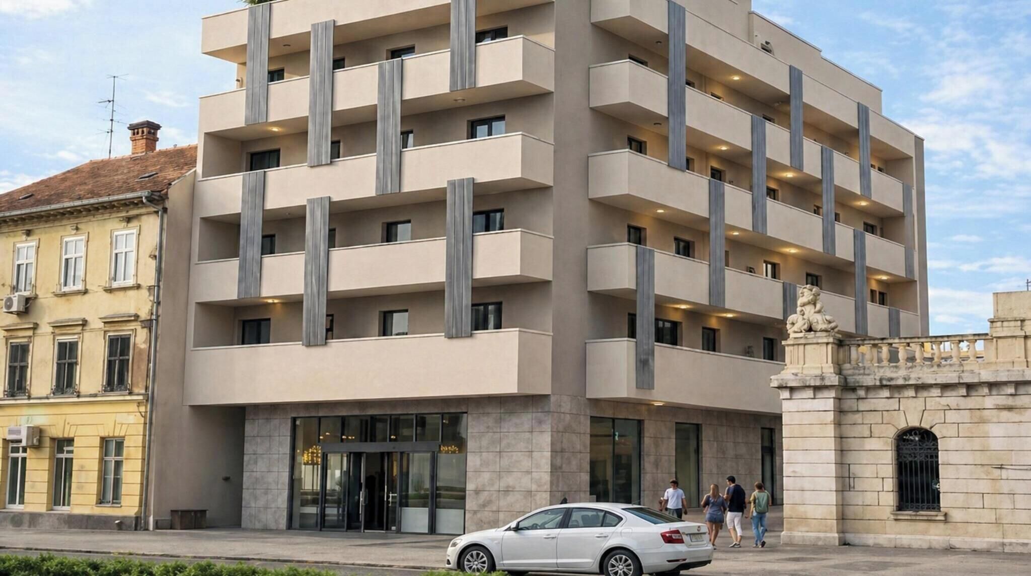 A multi-story hotel with a modern design, featuring balconies, a central entrance, and a stone facade.