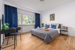 Ein modernes Schlafzimmer mit einem Bett, einem Nachttisch und einem Fenster mit Vorhängen.