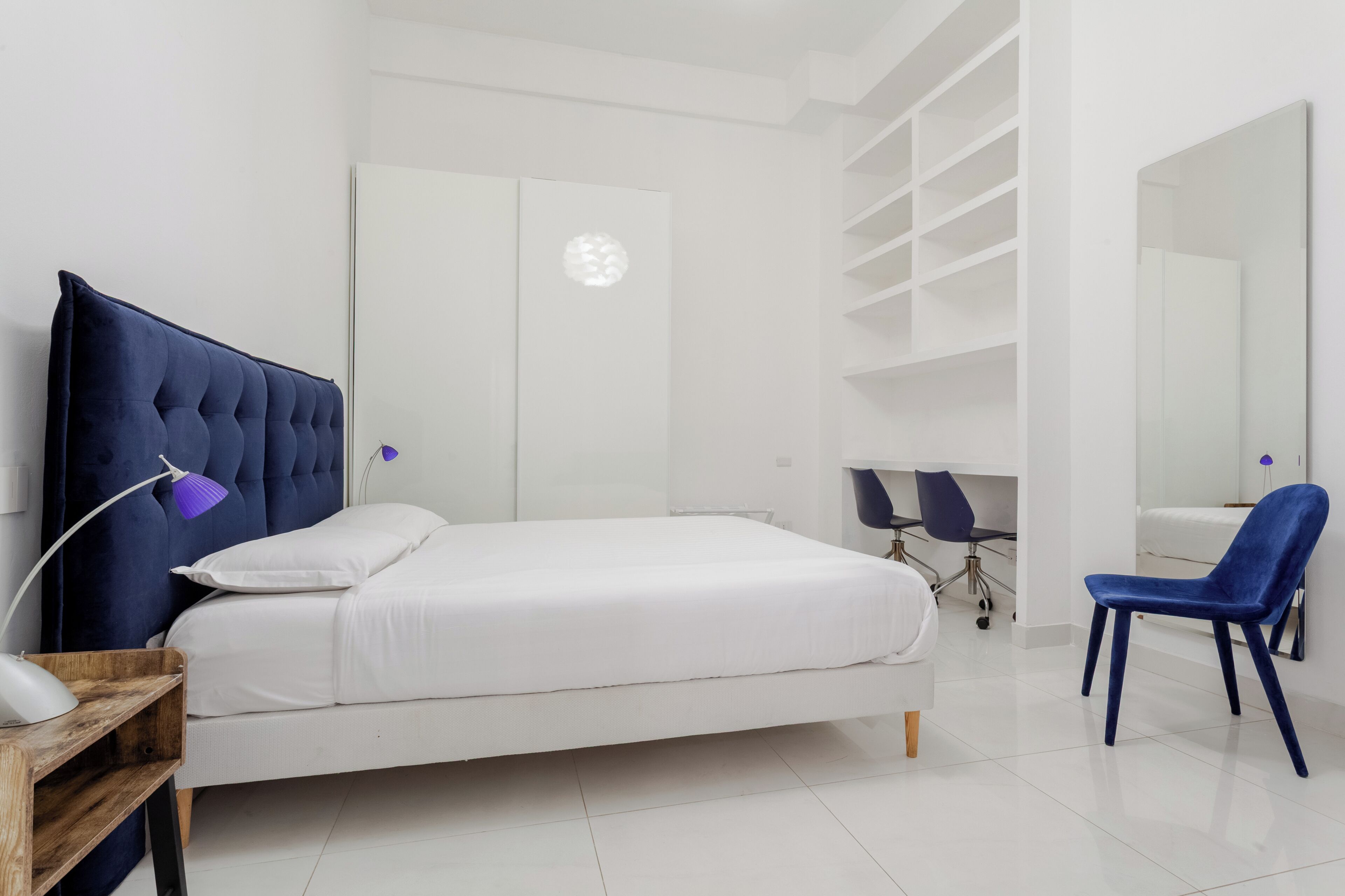Une chambre à coucher avec un lit, un bureau, une chaise et une armoire.