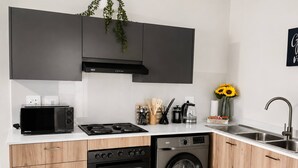 A modern kitchen with a built-in oven, microwave, and dishwasher, along with a sink and a stove.