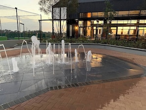 A water feature with multiple jets, surrounded by a paved area with a brick border. - The Modern Sanctuary (Boksburg)