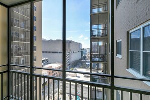 A high-rise building with multiple balconies, large windows, and a view of the surrounding urban area. - Modern Twist in a Historic Building, sleeps 6 (Atlanta)