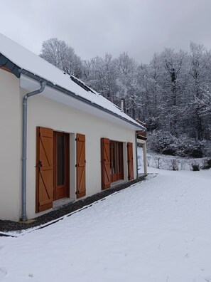 A building with a snow-covered roof, wooden shutters, and a paved driveway. - Family home in the mountains, in the Ossau Valley (Béost) (Béost)