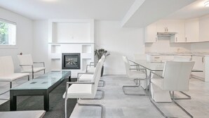 A modern kitchen with white cabinets, a marble countertop, and a built-in stove. - Fully Furnished House, Delta, BC, Canada, (Delta)