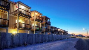 Un hotel a più piani con balconi e una recinzione in legno.
