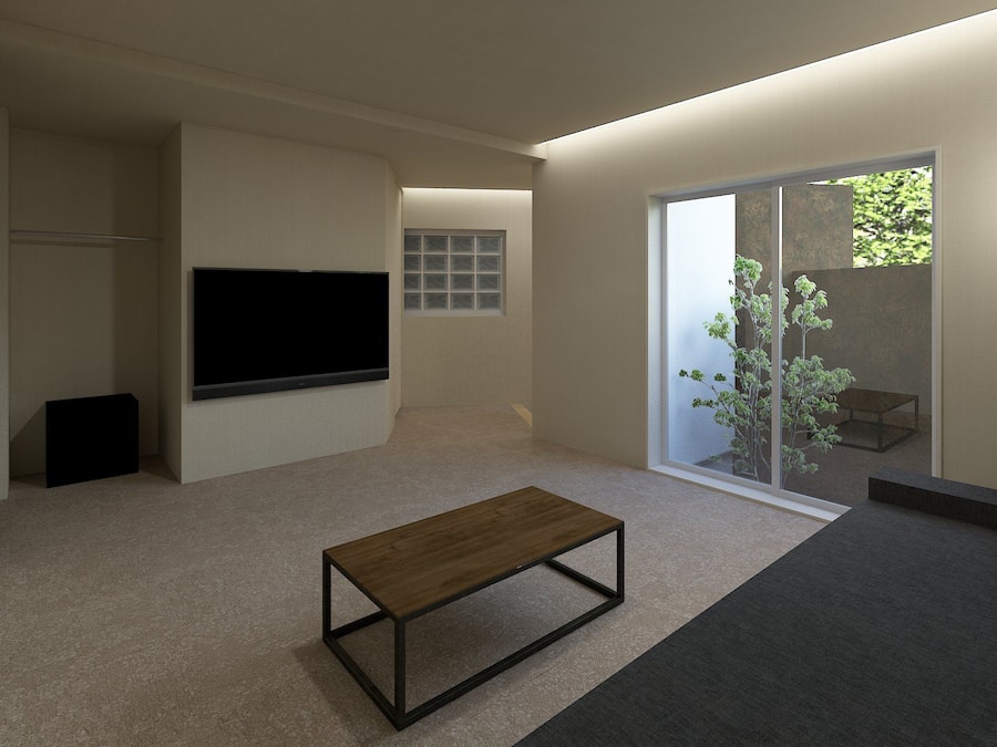 A modern living room with a flat-screen TV, a wooden coffee table, and a sliding glass door leading to a balcony with a plant.