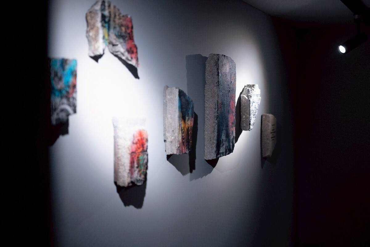 Eine Wand mit unterschiedlich geformten und -großen, steinartigen Objekten.