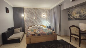 Een slaapkamer met een bed, een bank, een bureau en een stoel.