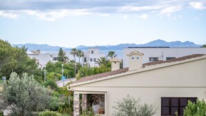 Zona residencial com casas, céu claro e montanhas ao fundo.