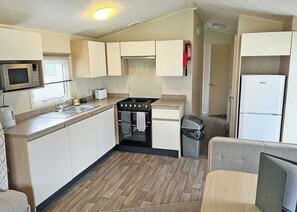 Fridge, oven, stovetop, toaster - A three bedroom 12ft wide holiday caravan with one double and two twins. (Morpeth)