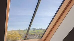 A skylight window with a view of a green landscape. - Morpeth (Chard)