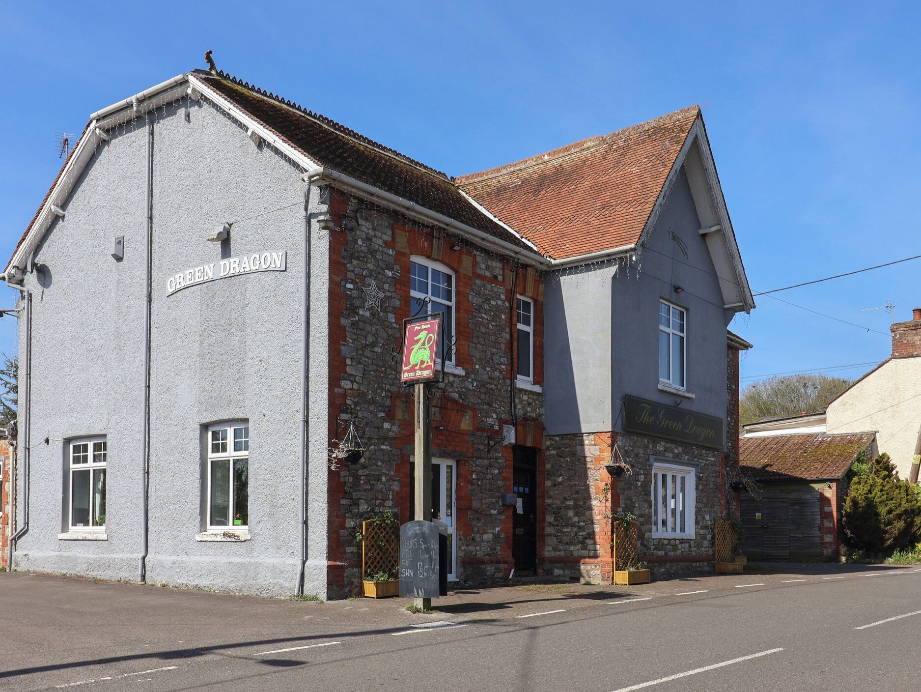 A two-story building with a sign reading 'GREEN DRAGON.'